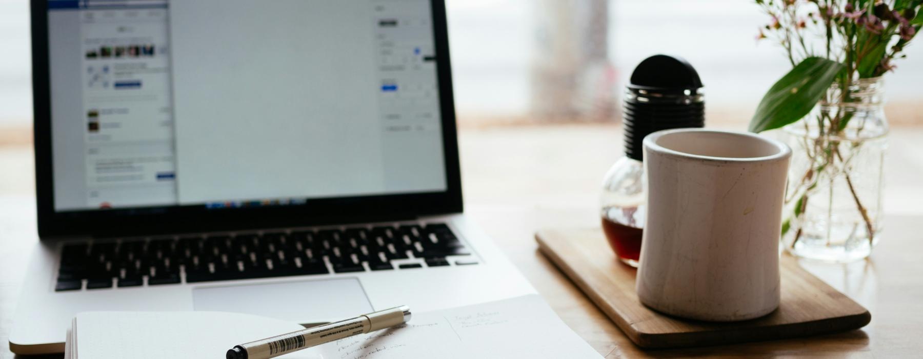 a laptop and a pen on a table