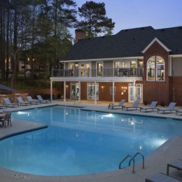a swimming pool in front of a clubhouse